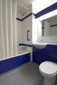 a bathroom with a toilet and a sink and a tub at Travelodge Limerick in Limerick