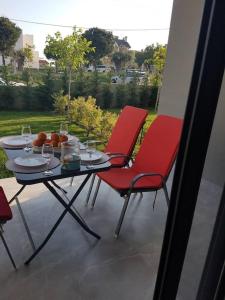 two red chairs and a table on a balcony at EP Luxury Olea Valley Apartment in Nikiti