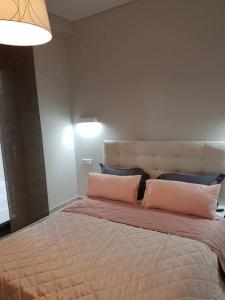 a bedroom with a large bed with pink pillows at EP Luxury Olea Valley Apartment in Nikiti