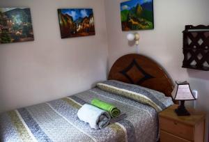 a bedroom with a bed with a green towel on it at Carlos Guest House 1 Cusco in Cusco