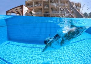 una persona en el agua en una piscina en Sunrise Apartments, en Sfakaki