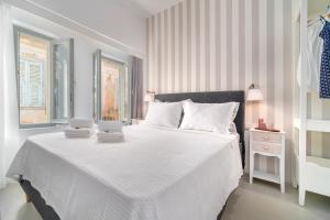 a bedroom with a white bed with two towels on it at Kastro Residence in Nafplio