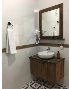 y baño con lavabo y espejo. en Sarı Konak Butik Otel en Gure
