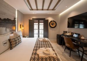a bedroom with a bed and a desk in a room at Hotel Santo Crist La Ciudadela Marbella in Marbella