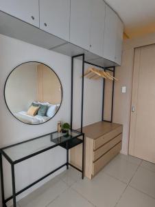 - une salle de bains avec un miroir et un lit dans une chambre dans l'établissement Breezy Tagaytay Condo, à Tagaytay