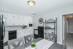 a kitchen with white cabinets and a table and chairs at 3 bedroom showstopper near Mayo Clinic in Rochester