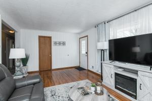 a living room with a couch and a television at 3 bedroom showstopper near Mayo Clinic in Rochester