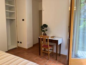 a bedroom with a desk and a table with a plant at relaxing green panorama in Margno