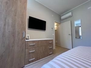 une chambre avec un lit et une télévision au mur dans l'établissement Turums B&B, à Castellammare del Golfo