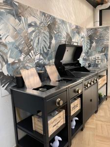 a kitchen with a black counter with a tropical wallpaper at Curtigghiu Mondello in Mondello