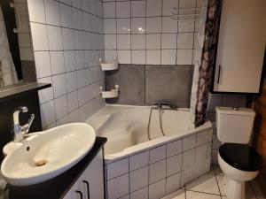 bagno con vasca, lavandino e servizi igienici di Maison au bord du canal 