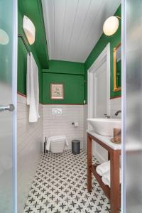 a bathroom with a white sink and green walls at Kastro Residence in Nafplio