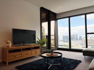 una sala de estar con TV de pantalla plana en un armario de madera en Astonishing Southbank Pearl Tower Residences near Crown Casino, en Melbourne