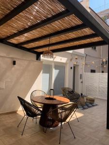 eine Terrasse mit einem Tisch und Stühlen auf dem Dach in der Unterkunft Curtigghiu Mondello in Mondello