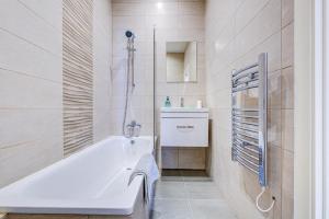 a bathroom with a white tub and a shower at Spacious and Modern 1 Bed 1 Bath Apartment in the Heart of Eastbourne in Eastbourne