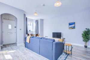 a living room with a blue couch and a tv at Spacious and Modern 1 Bed 1 Bath Apartment in the Heart of Eastbourne in Eastbourne