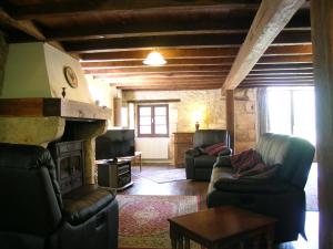 sala de estar con 2 sofás y chimenea en Totally Secluded Stone Cottage with Private Pool, 2 acres of Garden and Woodland, en Paussac-et-Saint-Vivien