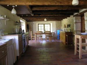 cocina con mesa y sillas en una habitación en Totally Secluded Stone Cottage with Private Pool, 2 acres of Garden and Woodland, en Paussac-et-Saint-Vivien
