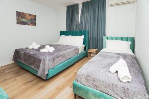 2 łóżka w pokoju hotelowym z ręcznikami w obiekcie New Apartment at New Bazaar - Tirana City Center w Tiranie