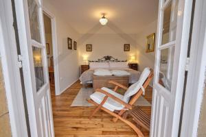 a bedroom with a bed and two chairs at Casona del Sol El Retorno I in Lastres