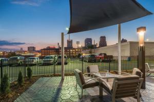 a patio with a table and chairs under an umbrella at La Quinta by Wyndham Memphis Downtown in Memphis