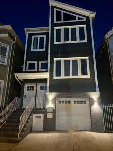 纽瓦克SPRINGVIEW HOMES 12MINS FROM EWR & 3 MINS FROM UNIVERSITY HOSPITAL的一间黑房子,设有白色窗户和车库