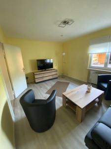 a living room with a table and a black chair at Ferienhaus MaLu in Nonnweiler +12 photos