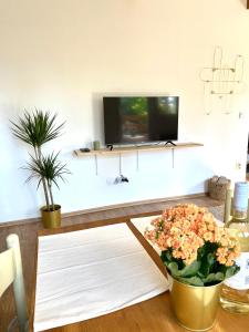 un soggiorno con TV e tavolo con fiori di Erdősor út Vendégház a Piliscsaba