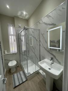 a bathroom with a shower and a sink and a toilet at Luxury 2 Bedroom Cottage in West Calder