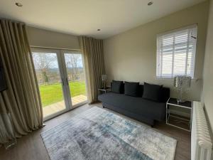 a living room with a couch and a large window at Luxury 2 Bedroom Cottage in West Calder