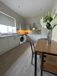 a kitchen with a table and a vase with white flowers at Luxury 2 Bedroom Cottage in West Calder