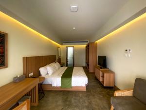 a hotel room with a bed and a television at Ayom Suite in Mataram