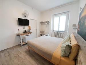 una camera con letto, scrivania e TV di BioBenessere Eco-B&B -Adults Only- Moto&Bike Parking ad Arezzo