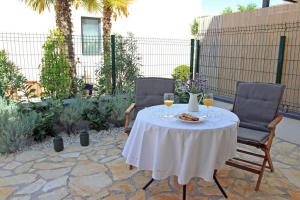 蘇提萬的住宿－Apartment Limoni，一张桌子、两把椅子和两杯葡萄酒