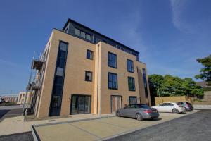 un edificio con dos coches estacionados frente a él en 2 Bedroom 2 Bathroom in ASHFORD - Next to Station - Perfect for 6 people - Parking & Super Fast Internet en Ashford