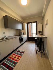 - une cuisine avec des placards blancs et un tapis de cuisine à l'étage dans l'établissement Turums B&B, à Castellammare del Golfo
