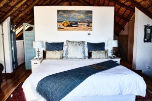 a bedroom with a large white bed with blue pillows at Gilcrest Place Guest House in Paternoster