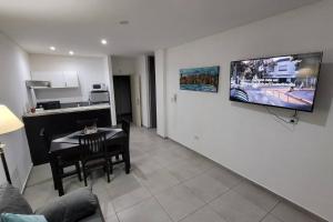 a living room with a table and a television on a wall at Departamento de Categoria Torre Costanera Norte, Corrientes in Corrientes