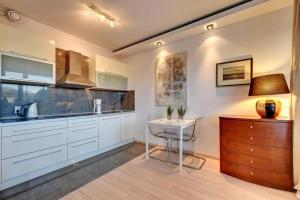 una cocina con armarios blancos y una mesa pequeña. en Central Apartments-Gdansk&Sz7/5, en Gdansk