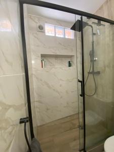 a shower with a glass door in a bathroom at La Suite des Platanes in Perpignan