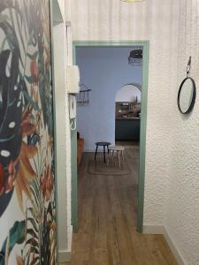 um corredor que leva a uma cozinha com uma mesa num quarto em La Suite des Platanes em Perpignan