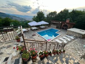 a swimming pool on a stone patio with plants at Villa White Dove Sarajevo in Sarajevo