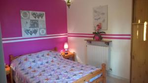 a bedroom with a bed and a purple wall at Gite Les Cigales in Labeaume