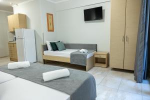 a small room with a bed and a refrigerator at R&M STUDIOS in Olympic Beach