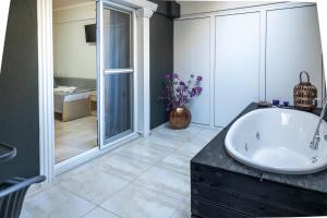 R&M STUDIOS في أولمبياكي أكتي: حمام مع حوض أبيض ومغسلة