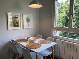 a dining room table with chairs and a white table at Apartamento Playa Ostende ,Garaje incluido in Castro-Urdiales