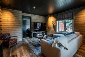 a living room with a couch and a television at Villa Vågå - by Classic Norway Hotels in Vågåmo