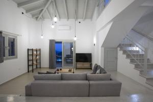 a living room with a couch and a tv at Panoutsis Villa Vista in Sívros