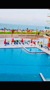 una piscina con agua azul, sillas y sombrillas en Porto Said Resort Rentals en Port Said