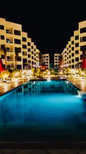 a large swimming pool in front of buildings at night at Porto Said Resort Rentals in Port Said